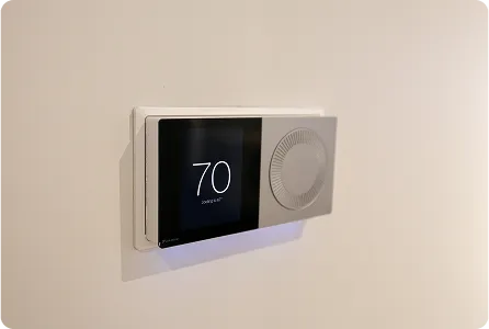 Modern digital thermostat with digital display showing 70 degrees