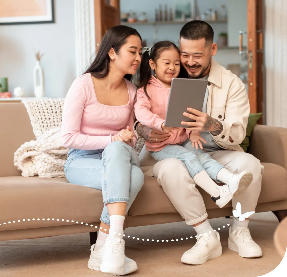 Family enjoying time together looking at tablet on cozy living room couch