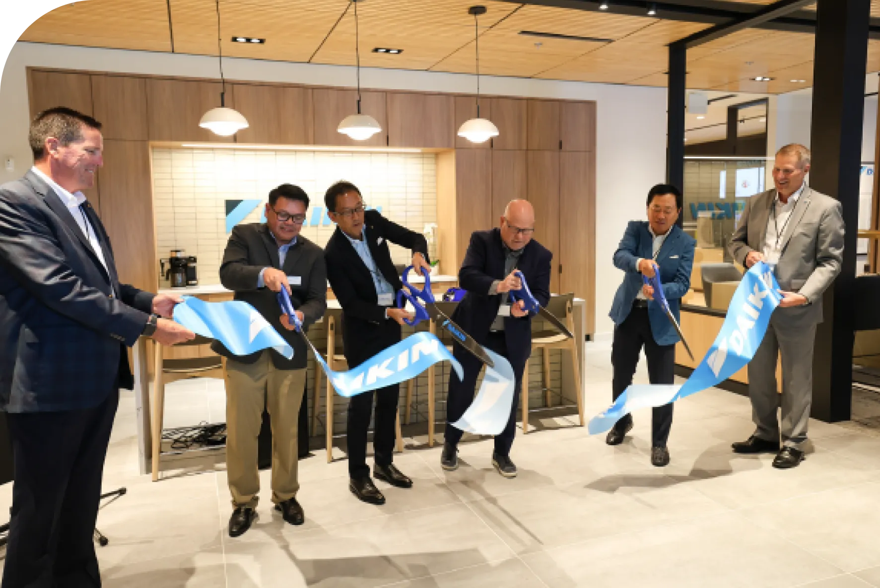 Business executives cutting blue ribbons at corporate office opening ceremony