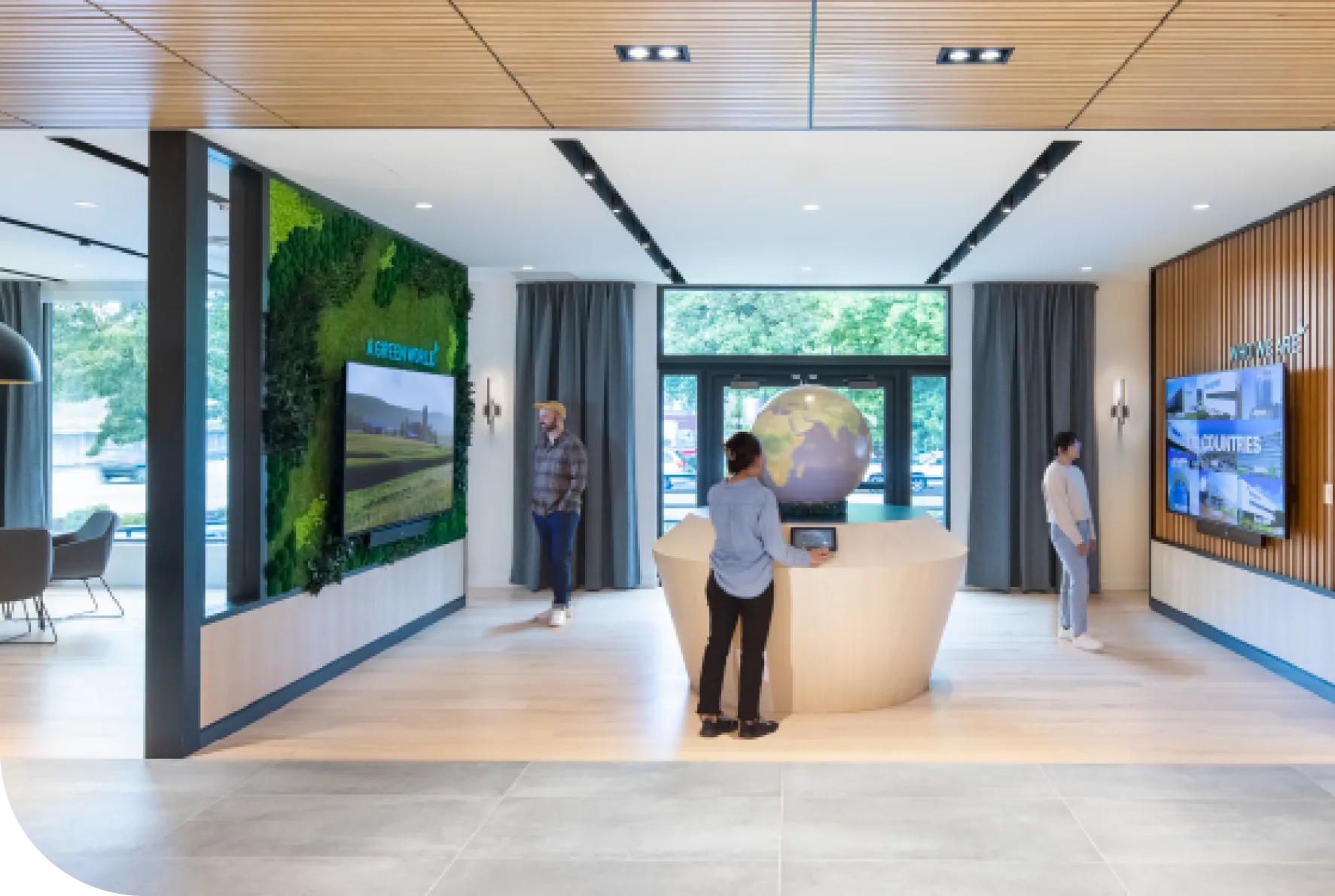 Modern office lobby with green wall, globe, and digital displays