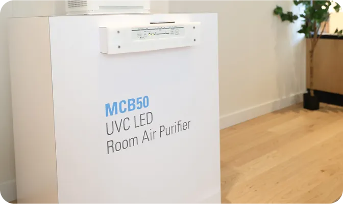 MCB50 UVC LED Room Air Purifier on wooden floor near houseplant