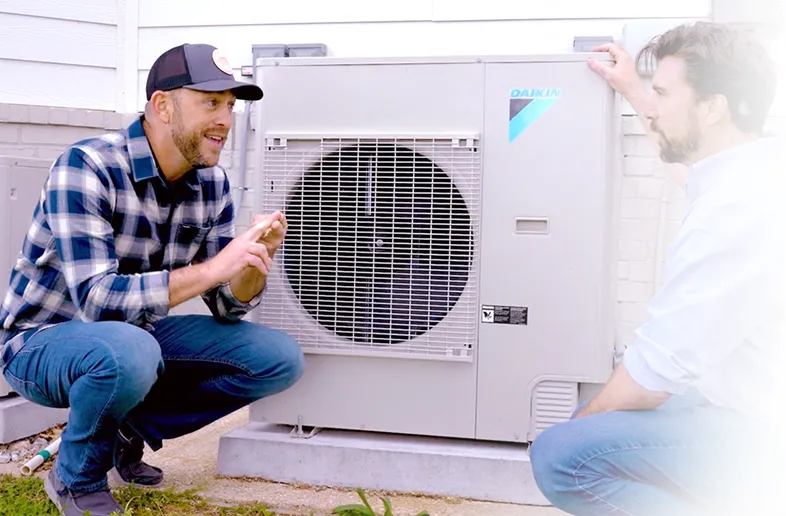 Two technicians discussing outdoor air conditioning unit installation