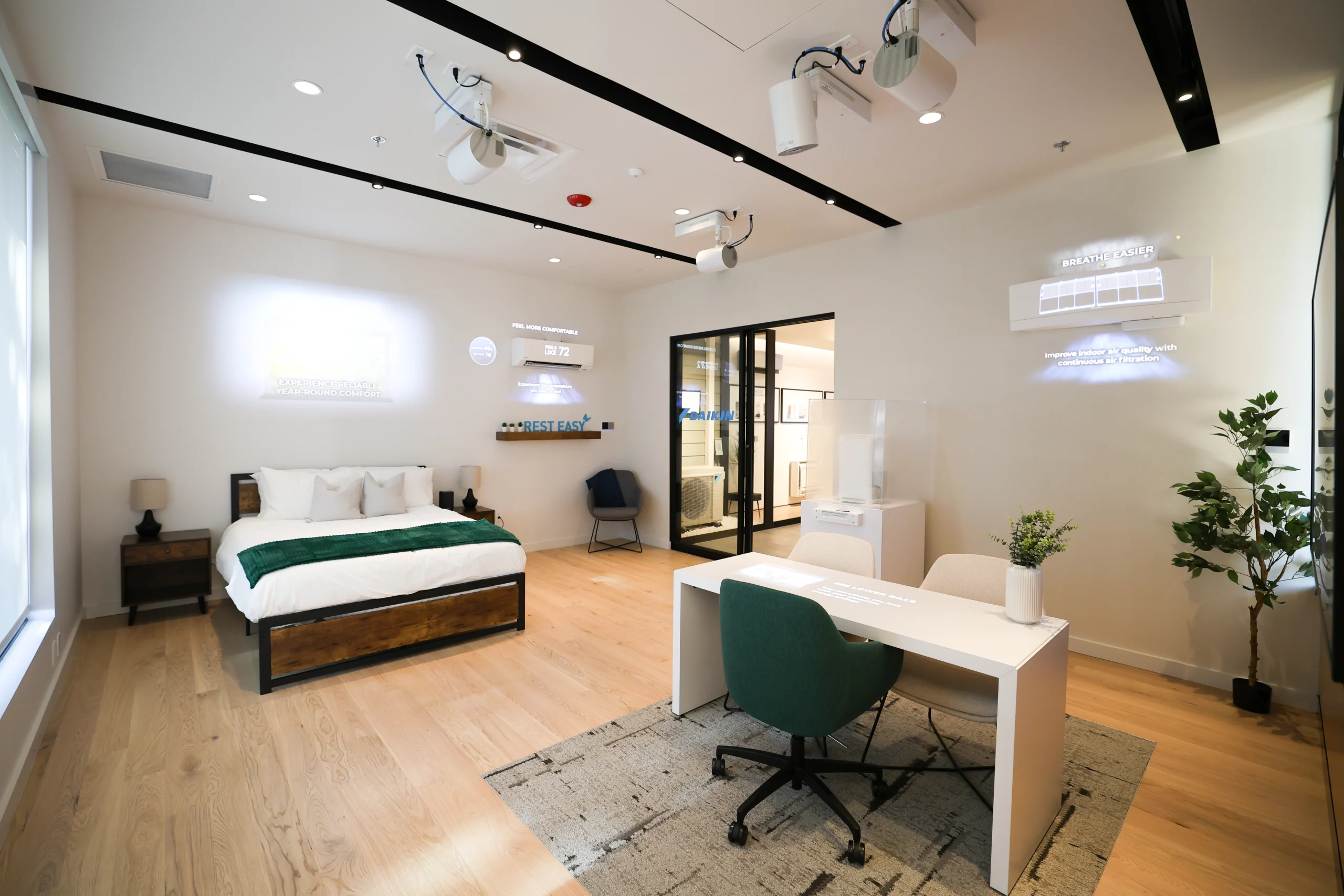 Modern bedroom with workspace, green accents, and digital information displays