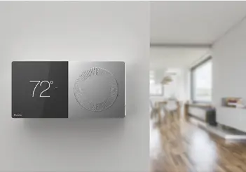 Modern digital thermostat set to 72 degrees on minimalist wall