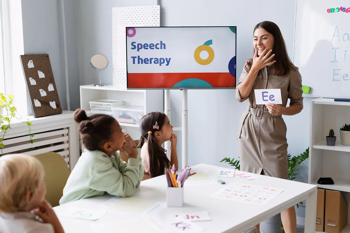 A teacher showing young English learners to use their mouth muscles to pronounce words properly