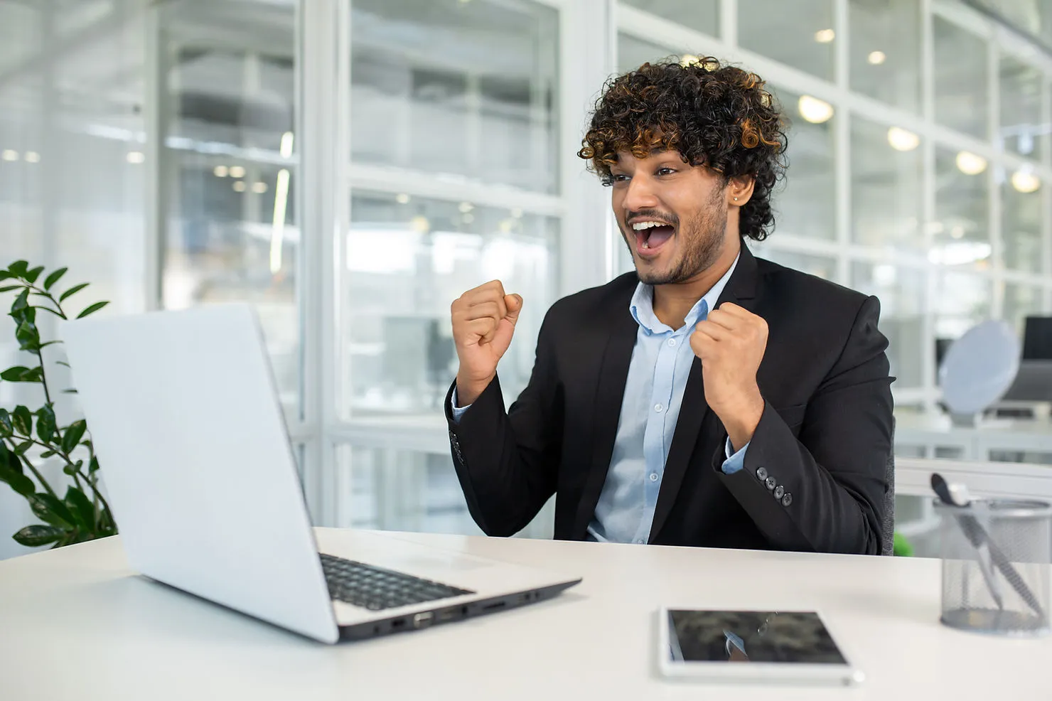 male-employee-celebrating-happy-on-desk-how-to-improve-online-tutor-retention-with-recognition-and-rewards-edge-tutor