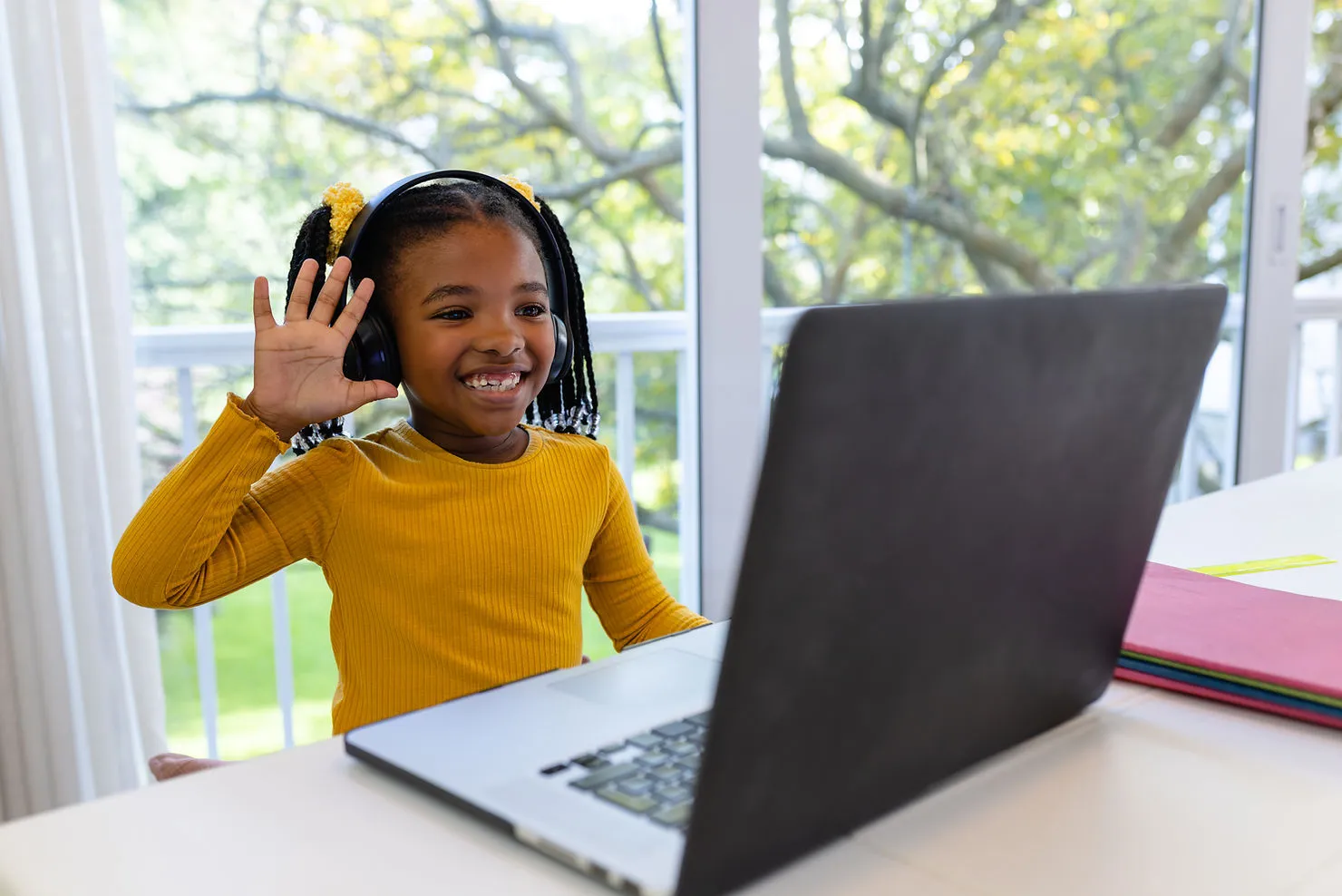 young-girl-saying-hi-to-laptop-online-learning-improving-esl-kids-language-skills-through-online-tutoring-edge-tutor