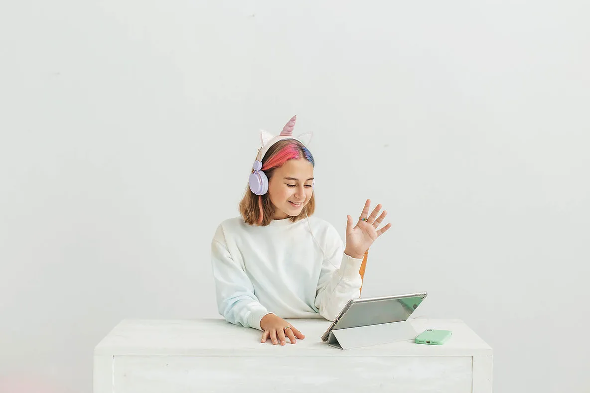 little-teenage-girl-in-headphones-communicating-on-laptop