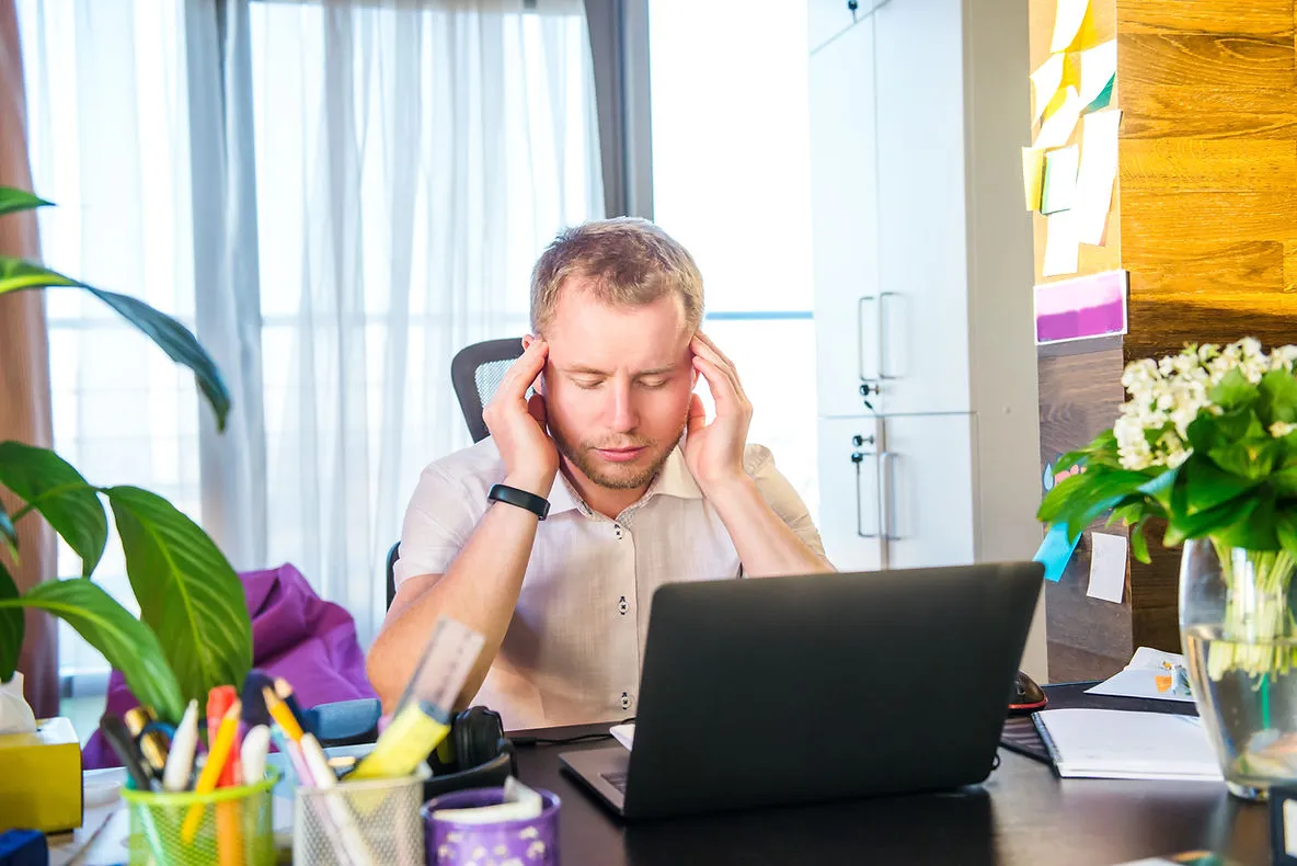 frustrated-man-holding-head-on-workspace-strategies-for-retaining-and-motivating-online-tutors-in-a-competitive-market-edge-tutor