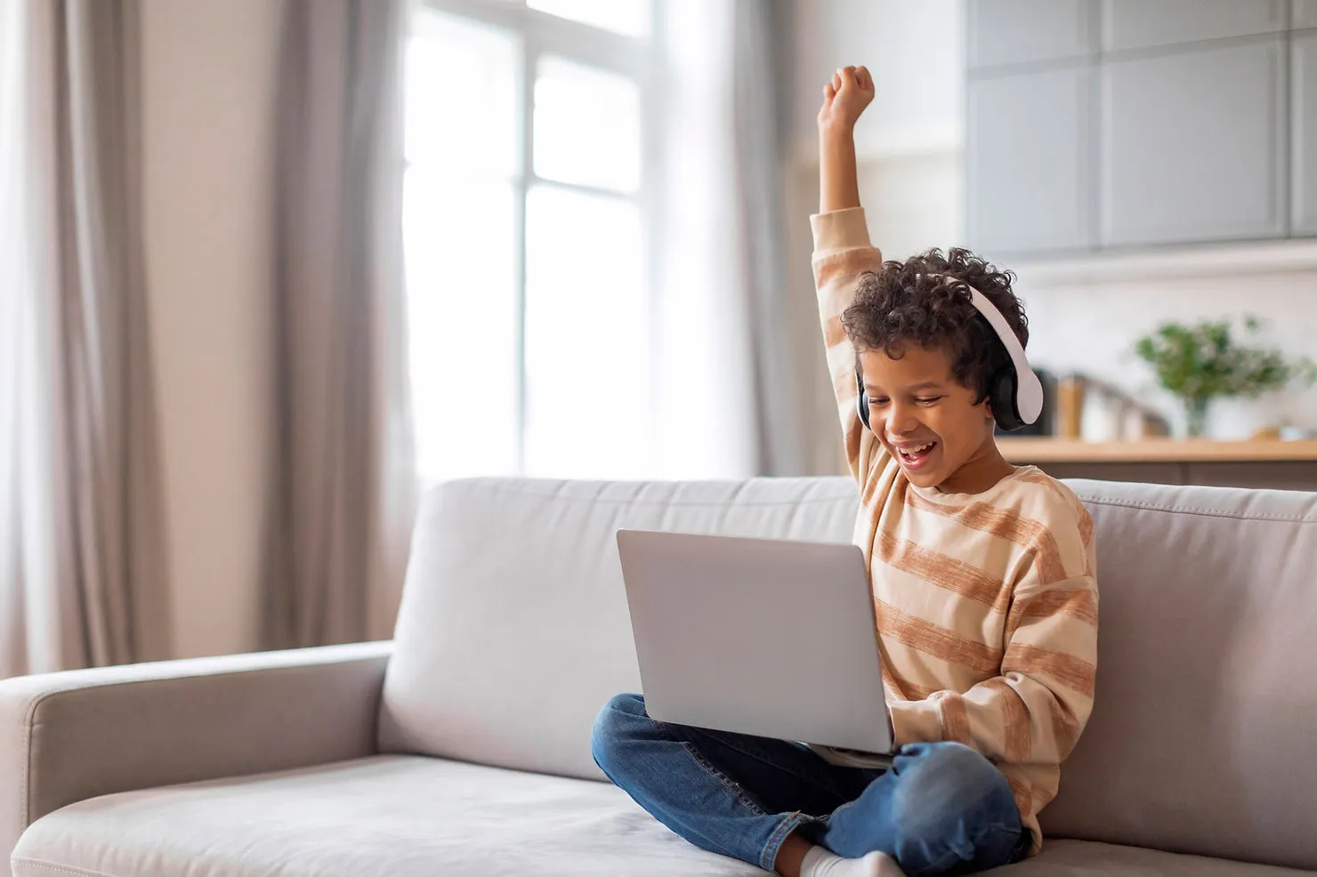 excited-boy-with-laptop-celebrating-success-why-advanced-english-skills-matter-for-teaching-kids-edge-tutor