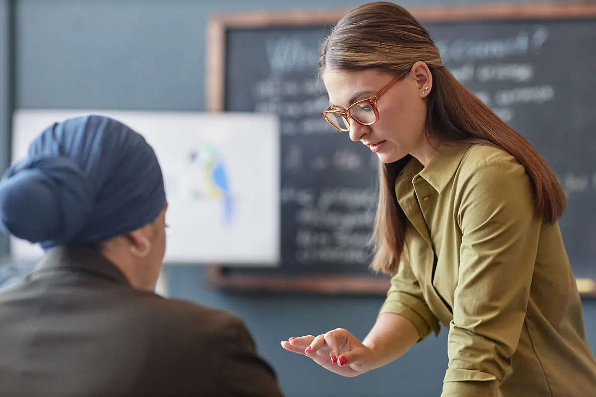 female-teacher-explaining-to-student-how-to-train-esl-students-to-speak-in-full-sentences-in-1-1-lessons-edge-tutor