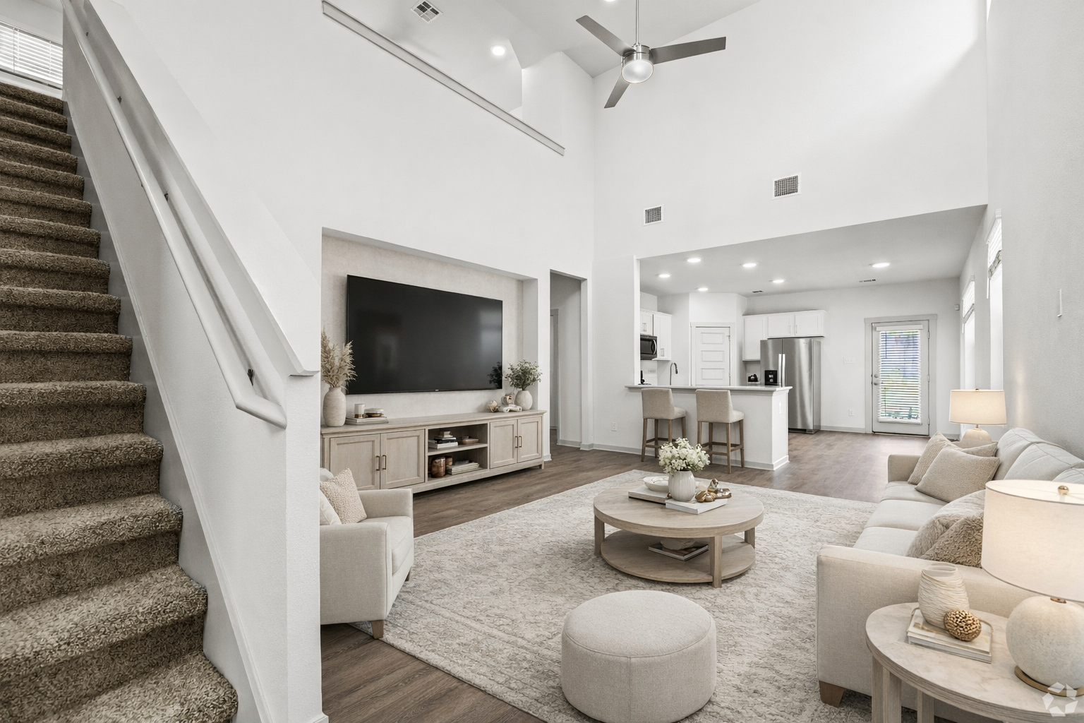 living area with tv and view of stair case
