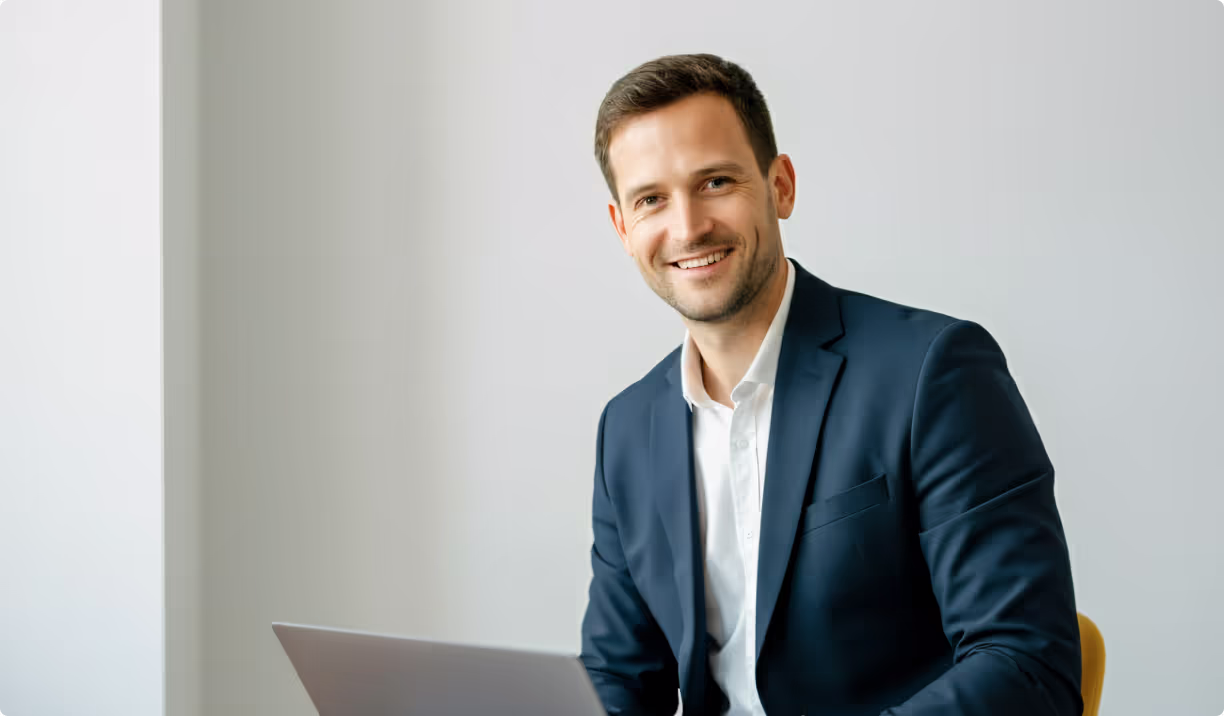 Lächelnder Geschäftsmann mit Laptop, Symbol für IT-Beratung und digitale Lösungen von Lions Solutions