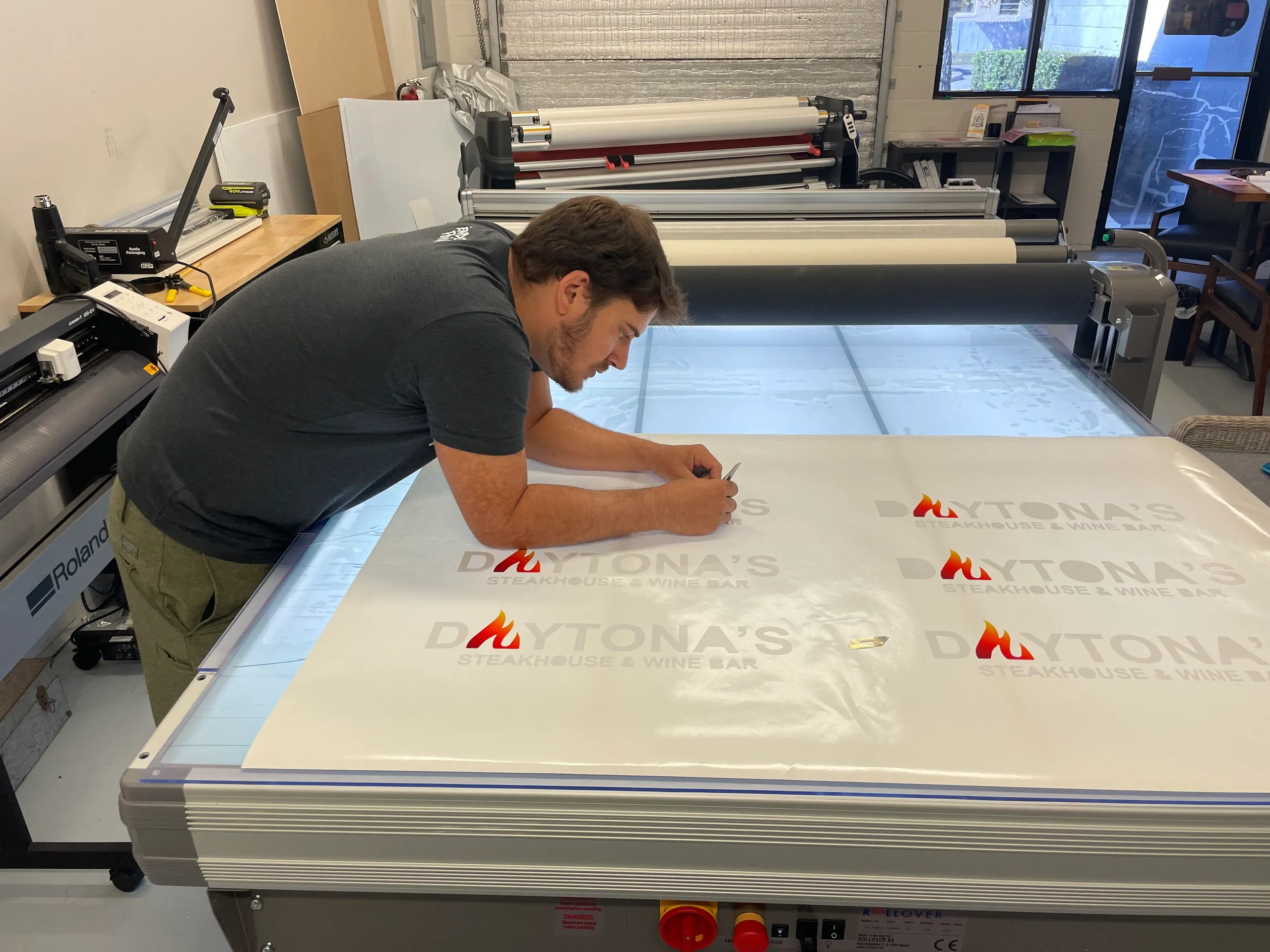 Photo of Evan Bayer, Owner of Castnet Media weeding vinyl for custom vinyl project