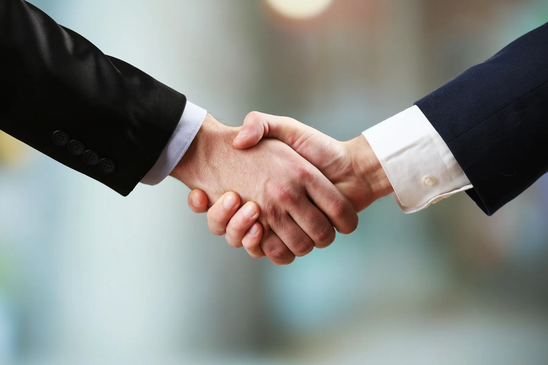 Business professionals shaking hands in a formal agreement or partnership