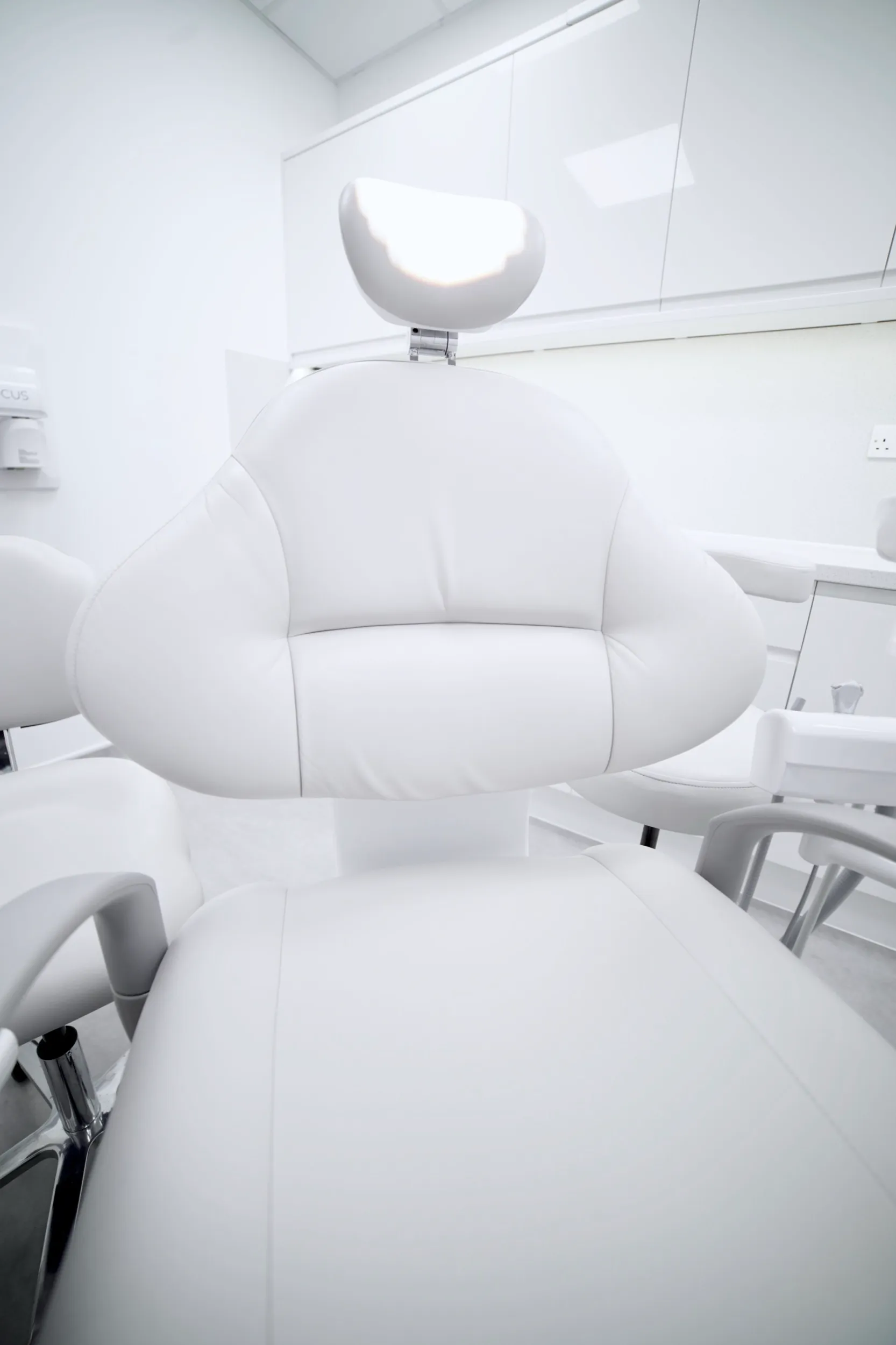 Clean, white dental chair in modern, minimalist examination room