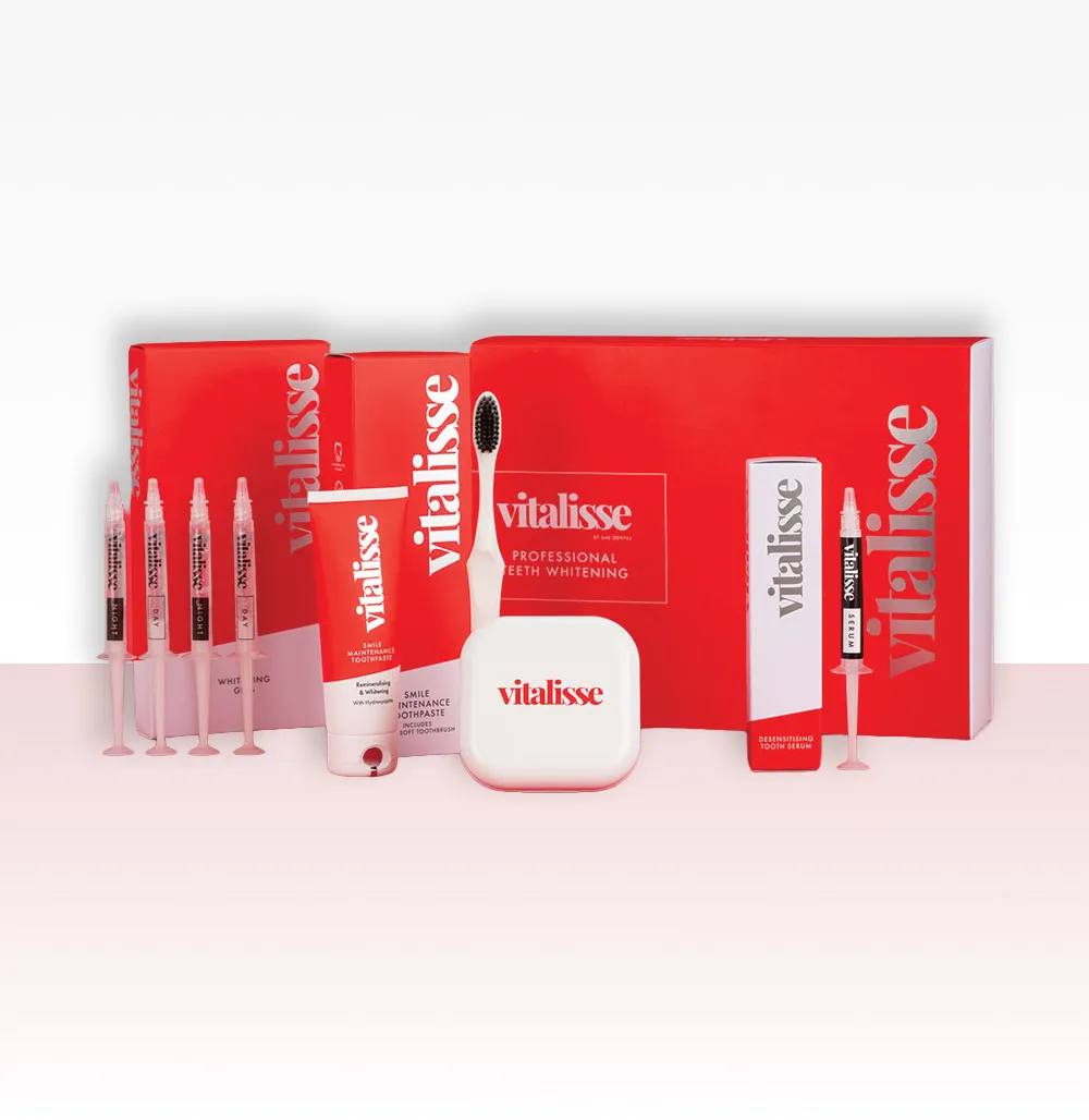 Set of Vitalisse professional teeth whitening products including whitening gel syringes, toothpaste tube, toothbrush, tooth case, and desensitizing tooth serum in red and white packaging.