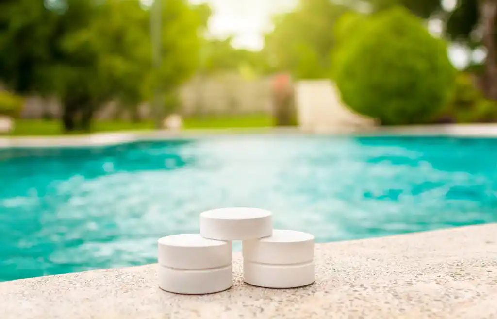 Chlorine tablets sitting poolside on a sunny day, used to keep water clear and safe for swimming.