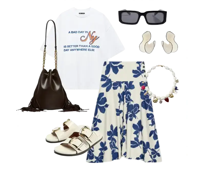 camiseta branca com frase de Nova York, saia midi branca com estampa floral azul, sandálias birken off-white com fivelas douradas, bolsa bucket de couro marrom escuro, óculos de sol retangulares, brincos metálicos, colar delicado
