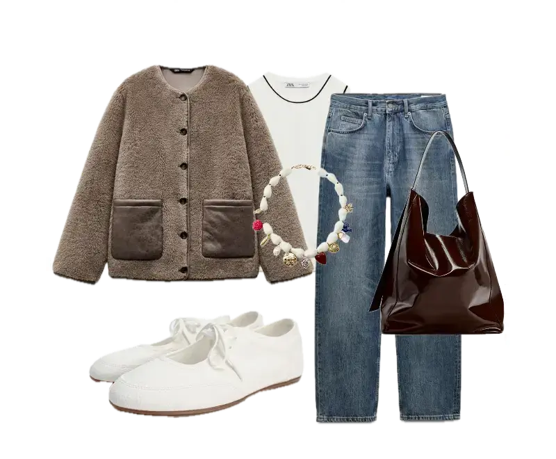 Casaco teddy oversized marrom, camiseta branca básica com detalhes pretos, calça jeans azul clara de corte reto, sapatilhas brancas de amarração, bolsa tote em couro marrom escuro, colar de pérolas multicoloridas