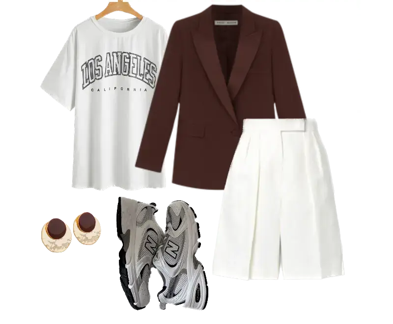 camiseta branca oversized, estampa gráfica escura, blazer marrom estruturado, bermuda de alfaiataria branca, tênis esportivos cinza, brincos circulares