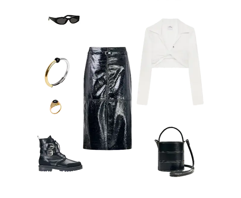 Cropped branco com design de blazer e lapelas, saia lápis preta de vinil, botas pretas de couro com fivelas, bolsa preta cilíndrica estruturada, óculos de sol pretos de armação geométrica, braceletes metálicos