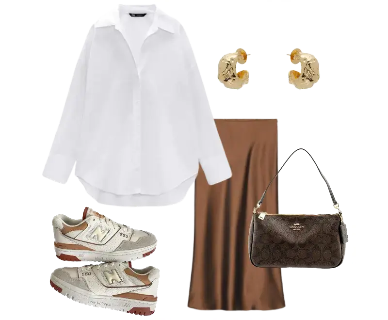 camisa oversized branca, saia midi acetinada marrom, tênis New Balance 550 bege e marrom, brincos dourados, bolsa de ombro Coach monograma marrom
