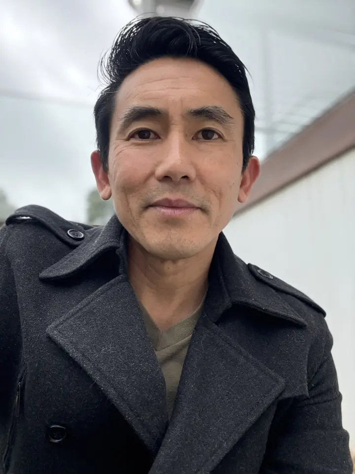 Benn Lim, certified Scaling Up coach based in Wollongong, smiling outdoors in a dark wool coat