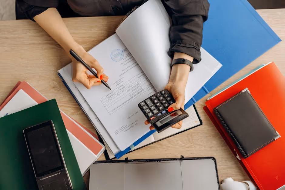 person reviewing loan documents with a calculator - best investment loan interest rates