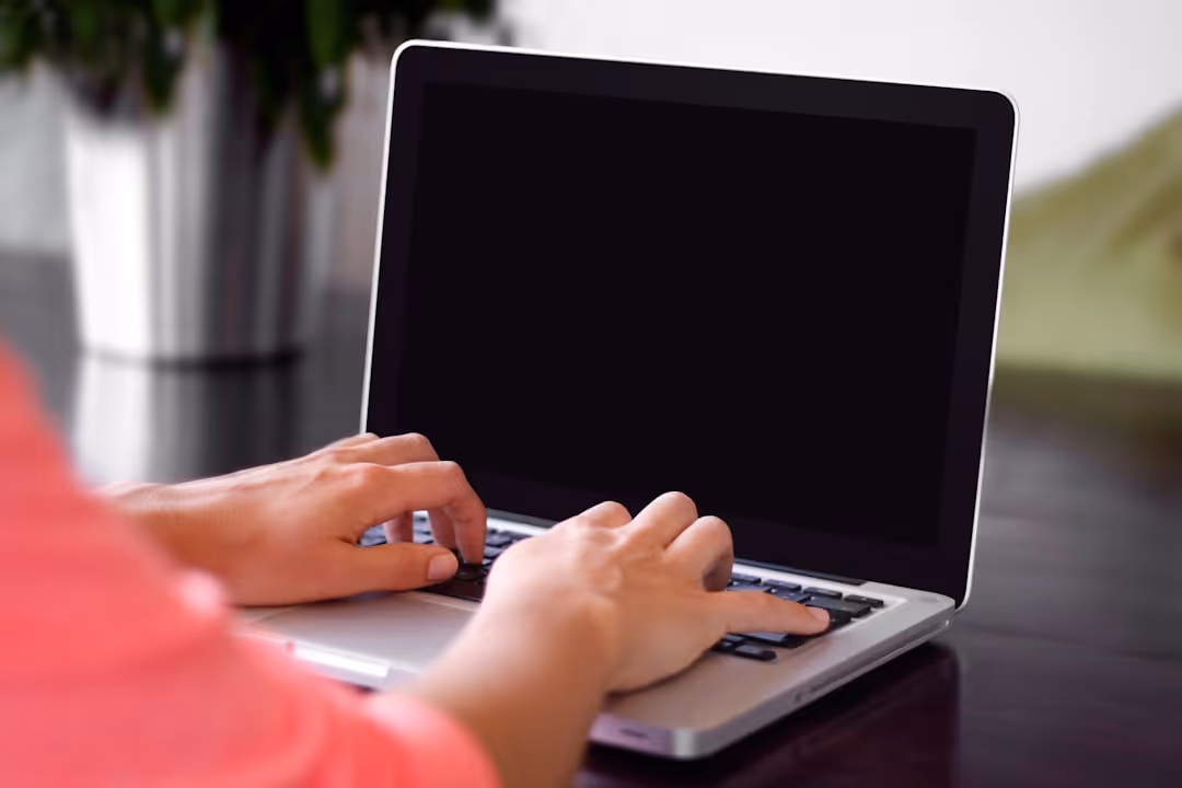 a person completing an online loan application on a laptop - short term real estate loan