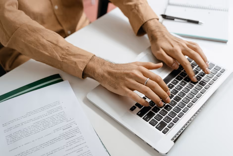 A person submitting documents online via a laptop - bridge loan application