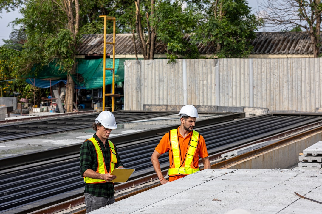 two professionals reviewing architectural plans on a construction site - advantages of direct lending for real estate projects