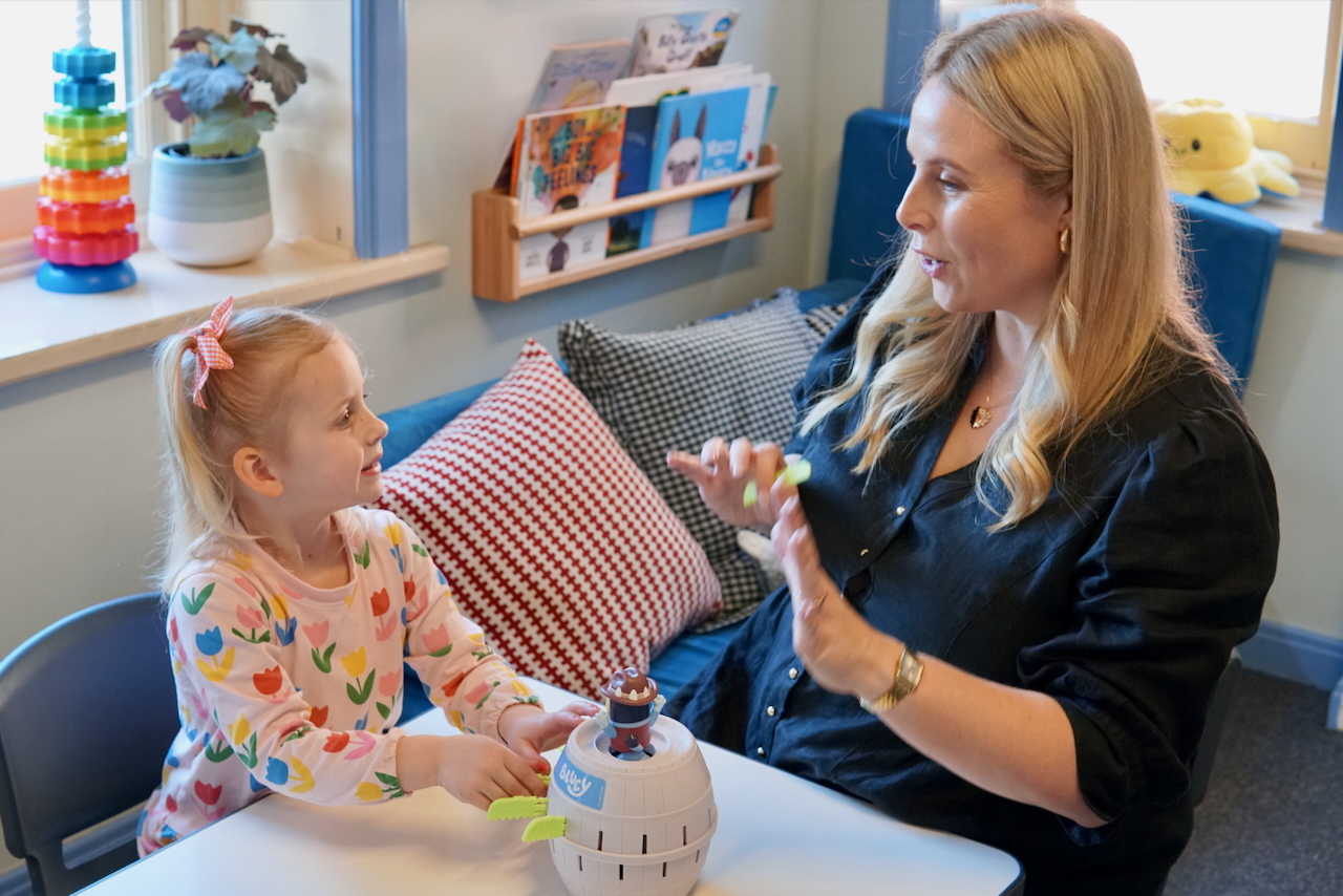 A child playing with a speech therapist at Zanda