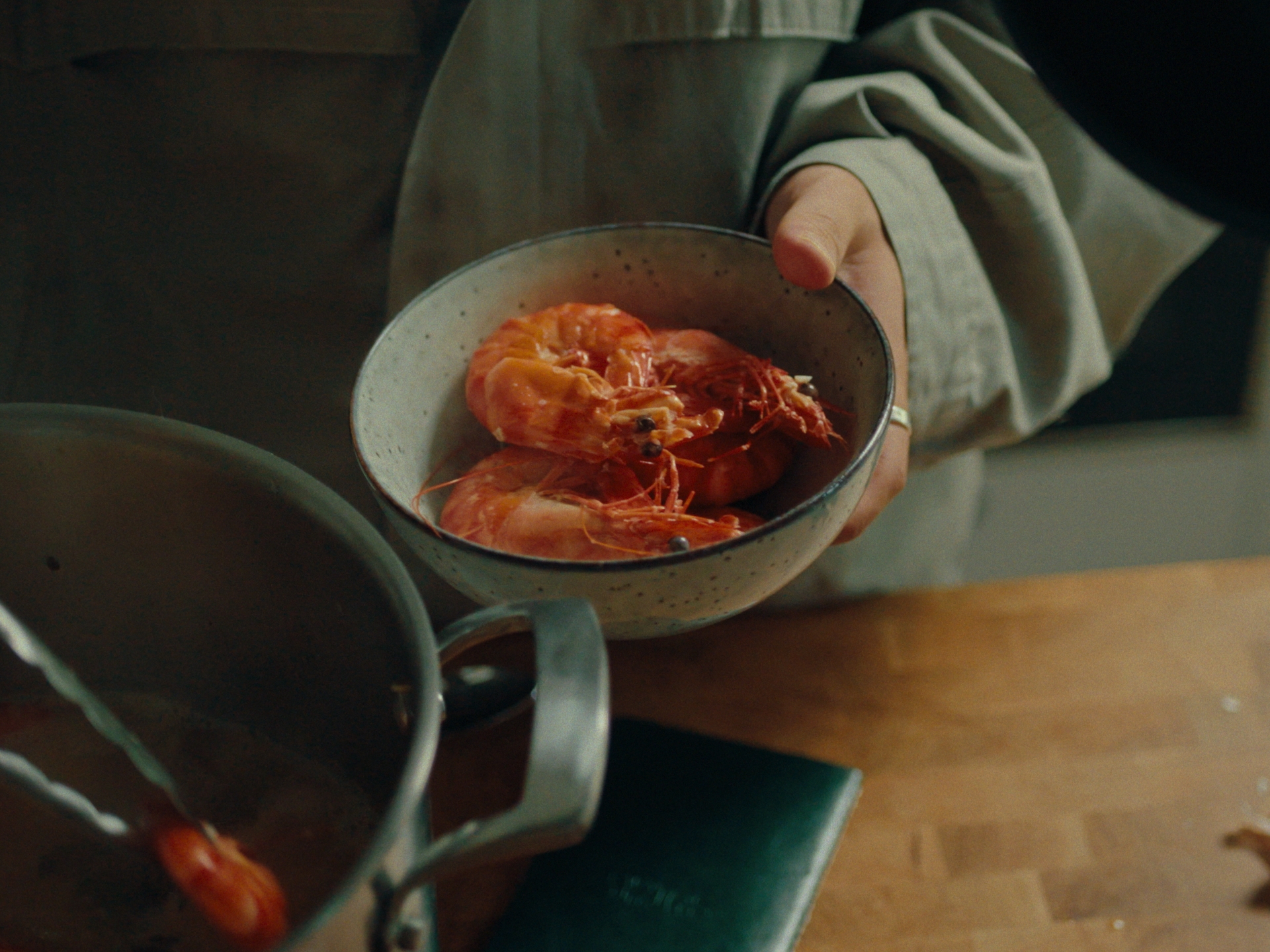 Cooked prawns lifted from the pot, the notebook on the bench below