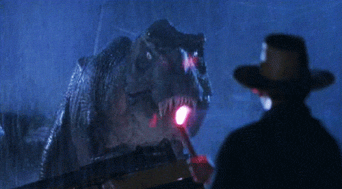 A scene from Jurassic Park where a character uses a flare to distract a roaring T-Rex in the rain.