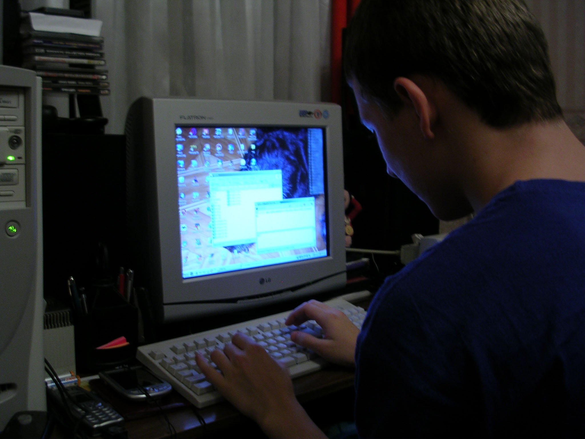 Anton programming at his crammed home desk on a bulky computer with a CRT screen in 2004