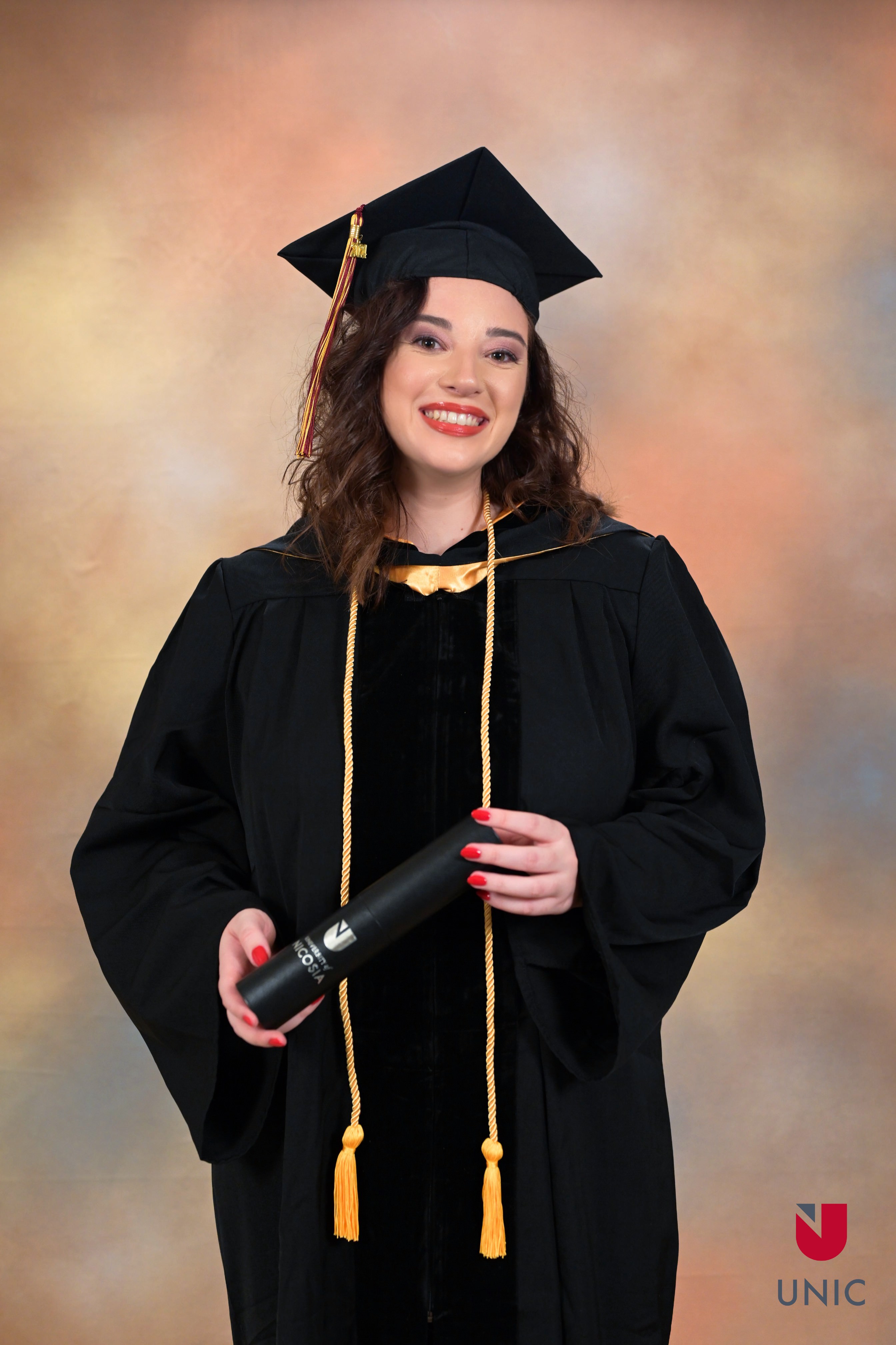 OctoProctor communication specialist and this article's author smiles gleefully as she graduates summa cum laude from a Master's program.