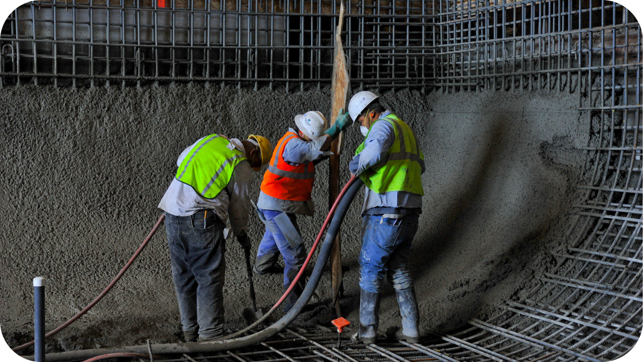 Construction crew wearing safety gear guiding a concrete hose inside a reinforced foundation, showing precise concrete pumping process in Melbourne.