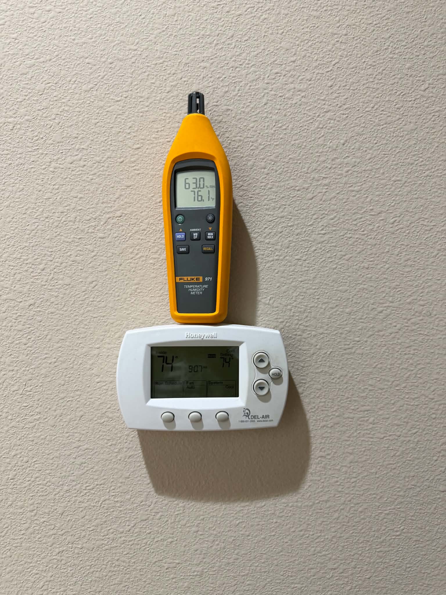Humidity meter reading 63% next to a thermostat set to 74 degrees in an uncomfortable Florida home