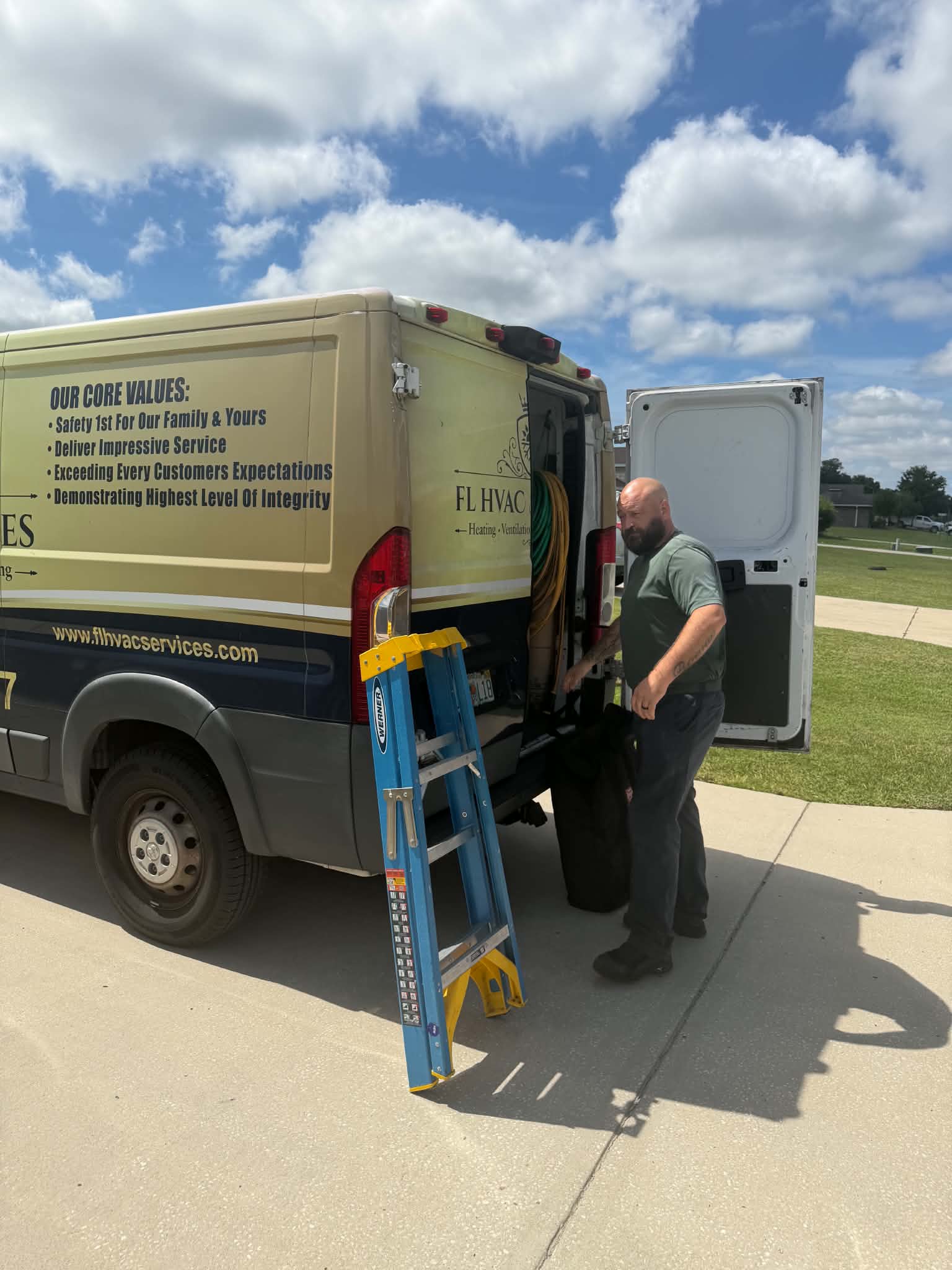 FL HVAC Services AC technician unloading equipment from the service van for an AC replacement at a Florida home