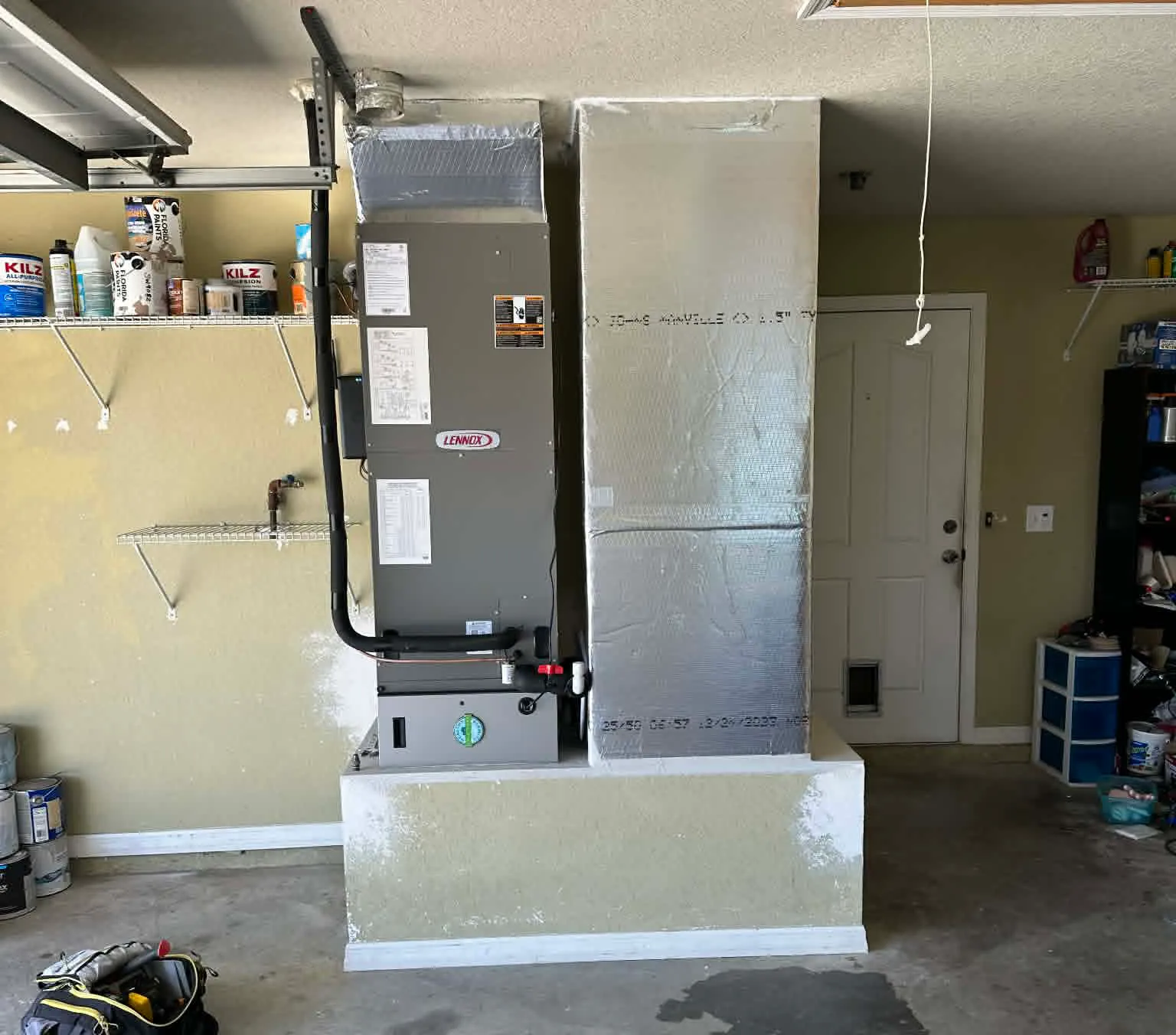 New Lennox air handler installed by FL HVAC Services on a raised stand in a Florida home garage