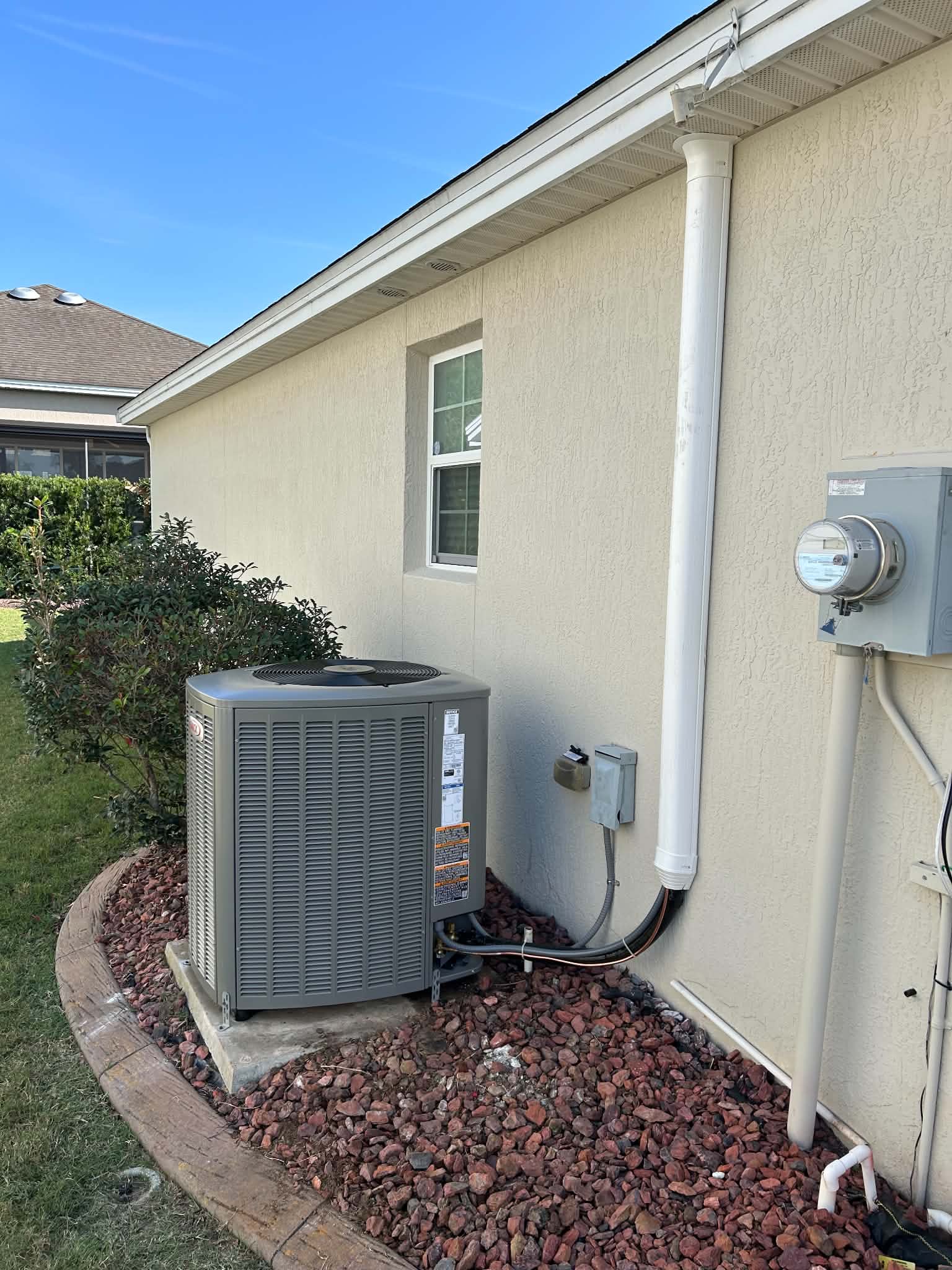 Lennox outdoor AC condenser installed by FL HVAC Services on a pad beside a Central Florida home