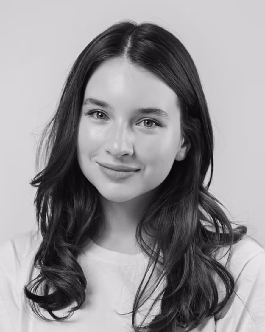 Young woman with long dark hair smiling softly in black and white portrait