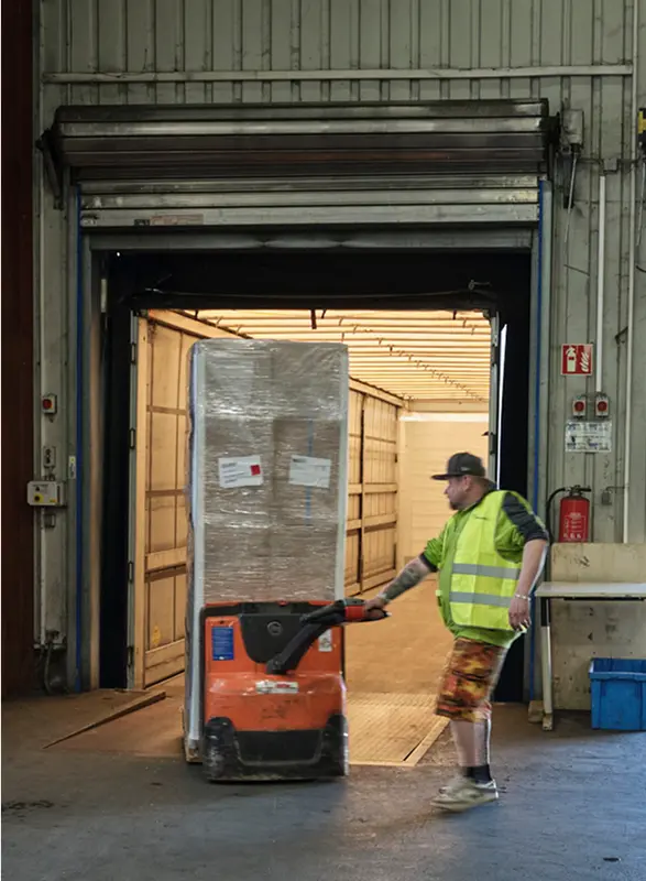 sicherer Stückgut Transport - Bildausschnitt eines Pohl-Mitarbeiter mit Hubwagen beim Verladen des LKWs