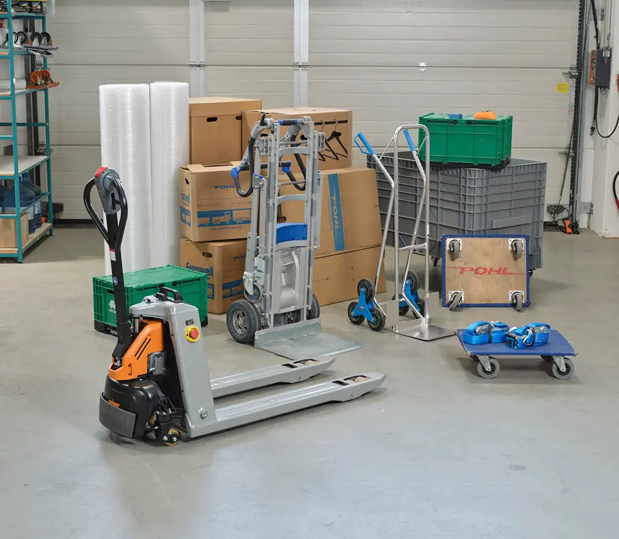 Umzugshilfsmittel von Pohl - ein Ventilator, Sessel, Kommode und Kartons stehen Transportbereit in einer Garage