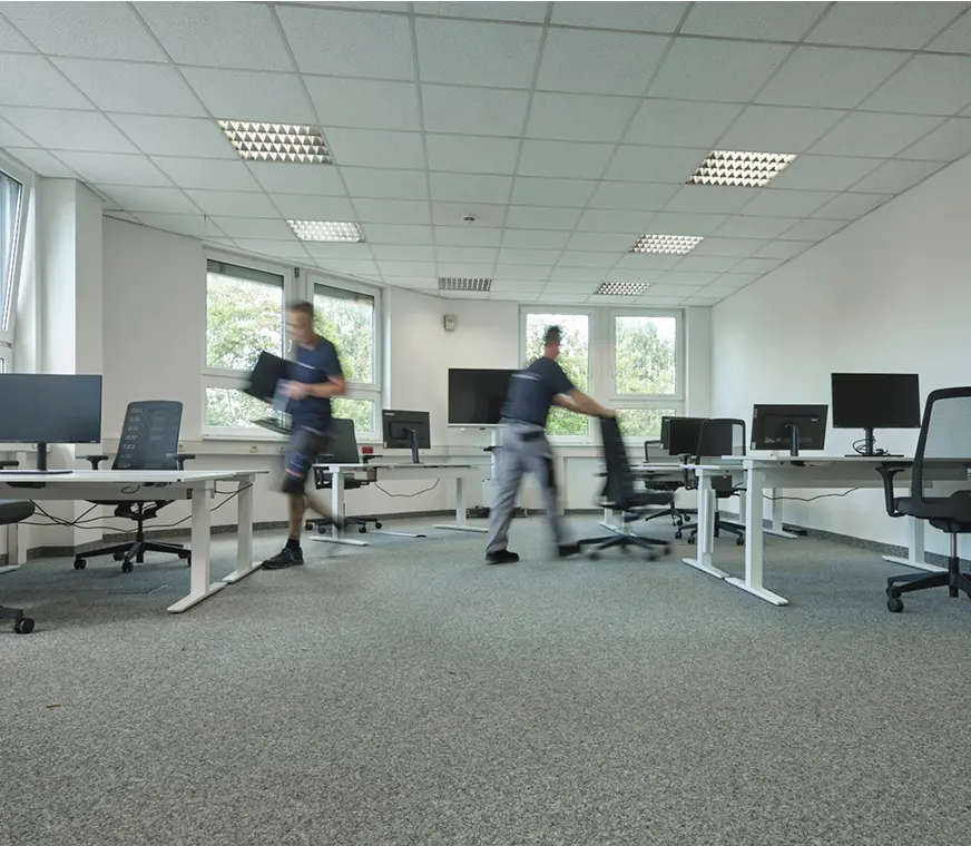 Gewerblicher Umzug mit Pohl - Zwei männer verräumen Möbel in einem Geschäftsraum  