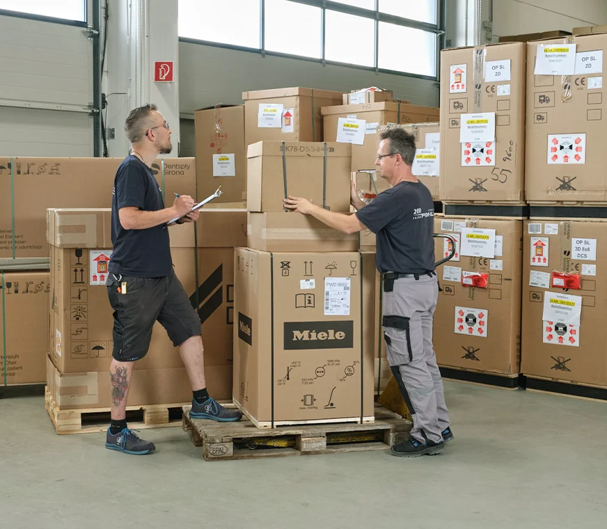 Gewerblicher Umzug mit Pohl - Zwei männer verräumen Möbel in einem Geschäftsraum  