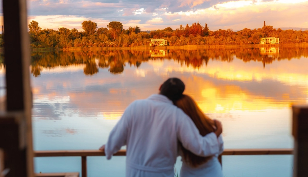 Couple en peignoir devant le lac au coucher du soleil