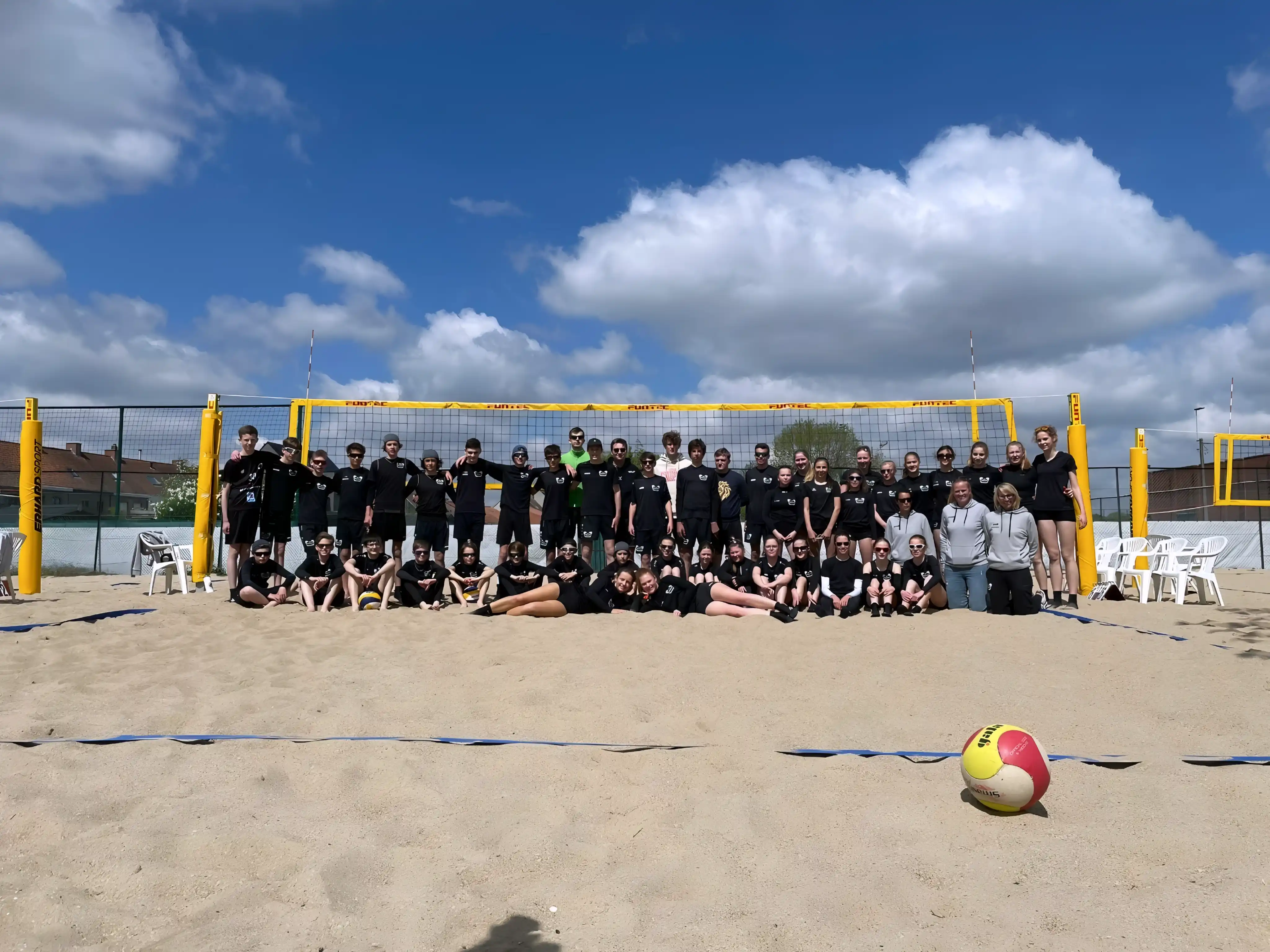 Ploegfoto van spelers van Rembert Beach op een beachvolleybalveld.