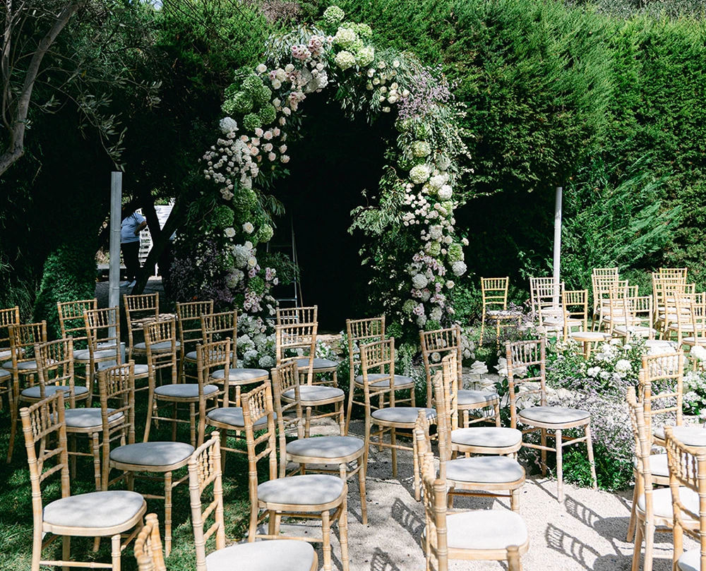 Lieu de cérémoni haut de gamme, Provence Alpes Côte d'Azur. Arche de fleurs et chaises pour accueillir les invités du mariage.